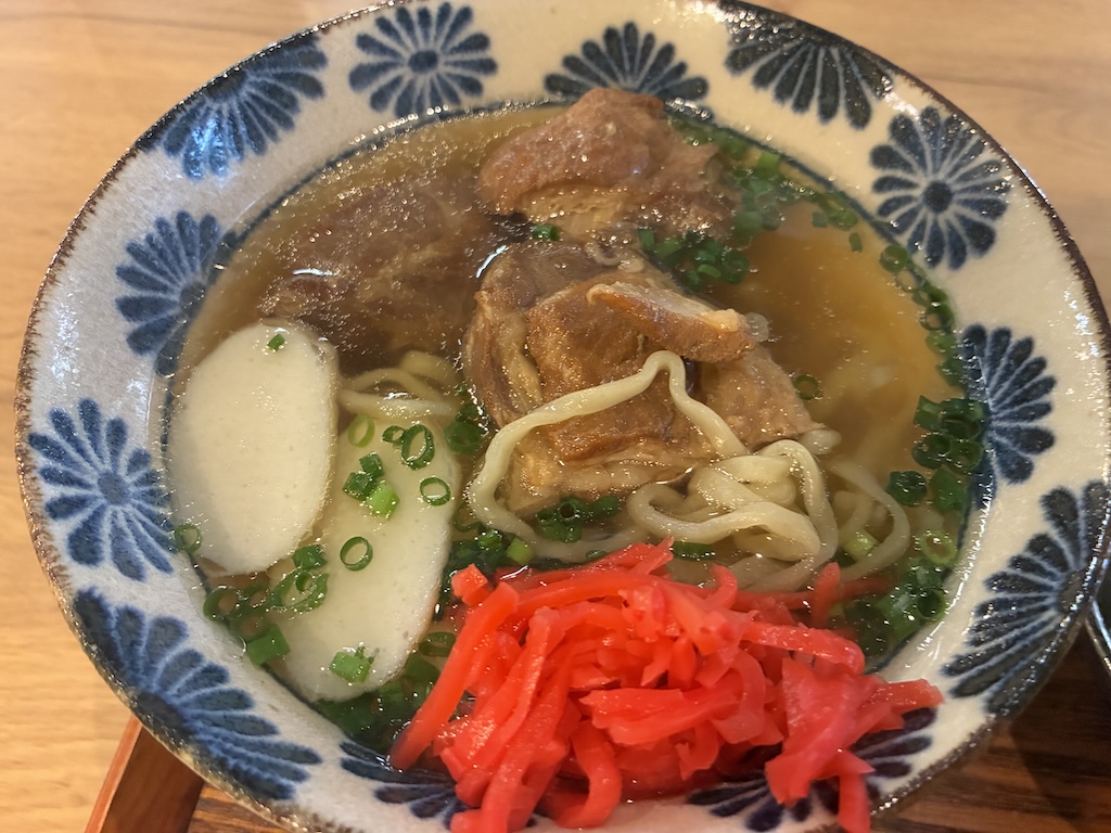 Authentic Okinawa soba with tender braised pork ribs sōki, fish cake kamaboko, and red pickled ginger beni-shoga at Naha Airport