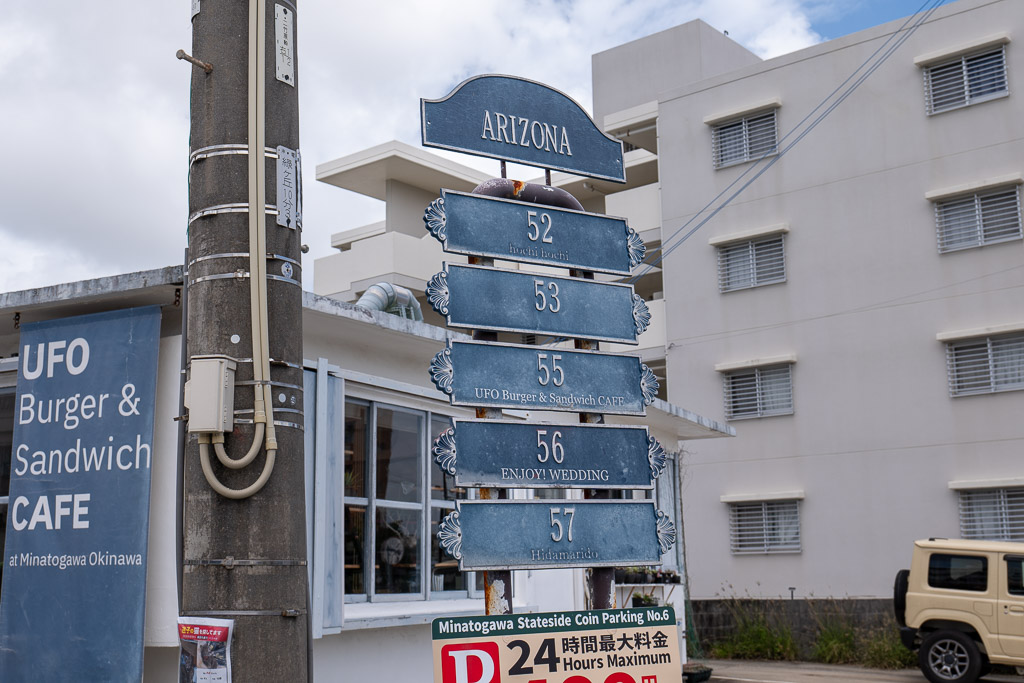 港川 (Minatogawa) ARIZONA block signboard, shops 52–57 — UFO Burger Sandwich CAFE ENJOY WEDDING Hidamarido