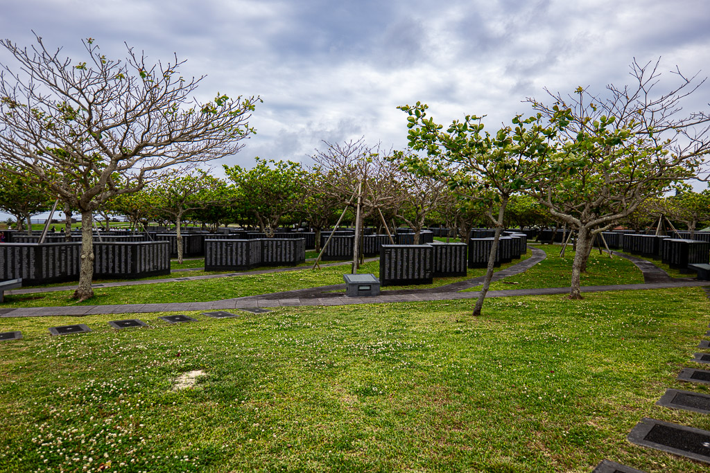 Memorial towers area on Mabuni Hill — rows of dark stone monuments under trees