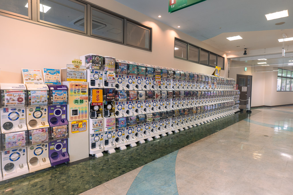 Gachapon corner at Okinawa World — wall of capsule toy machines