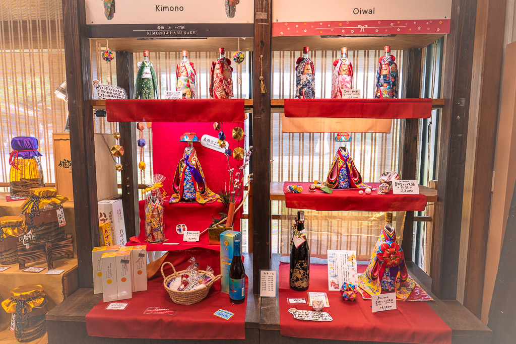 Okinawa World Ryukyu costume corner — Kimono and Oiwai bingata dolls with awamori bottles