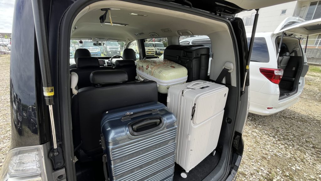 Toyota Voxy trunk — 3rd row half-folded, six suitcases loaded