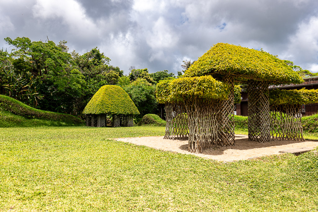 Living grass pavilions at Bios no Oka — two mushroom-shaped green pavilions stand on the lawn, woven from real plants