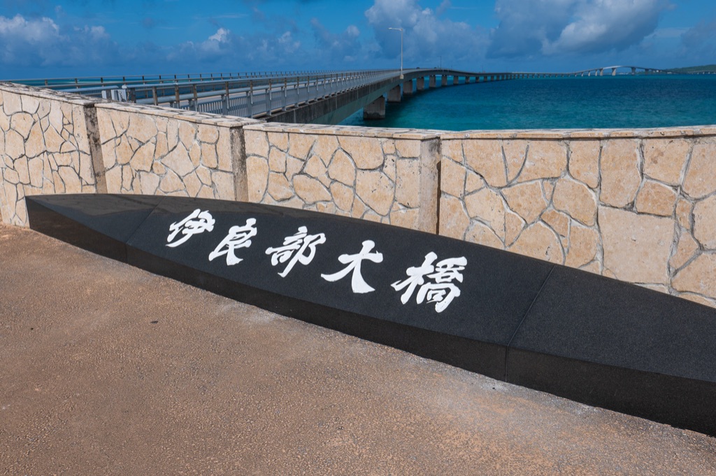Irabu Ohashi Bridge stone monument carved in kanji with the bridge stretching out behind
