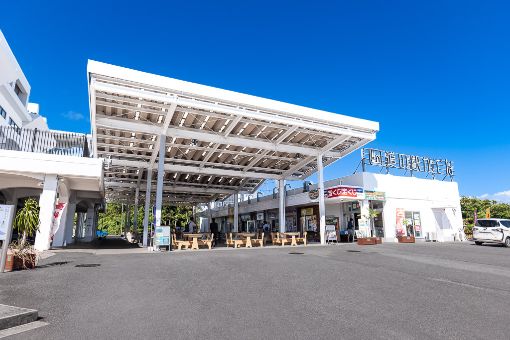 Spacious entrance plaza of Michi-no-Eki Kadena with a large solar-panel canopy and seating