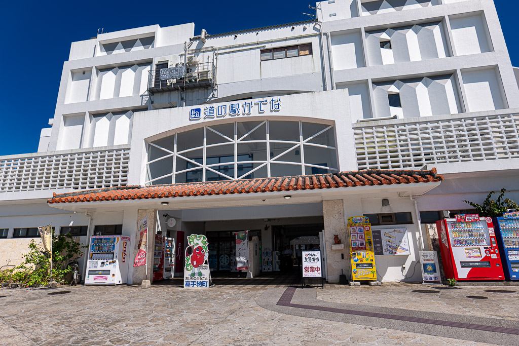 Main building of Michi-no-Eki Kadena with Okinawan red-tile eaves over the entrance and rows of vending machines