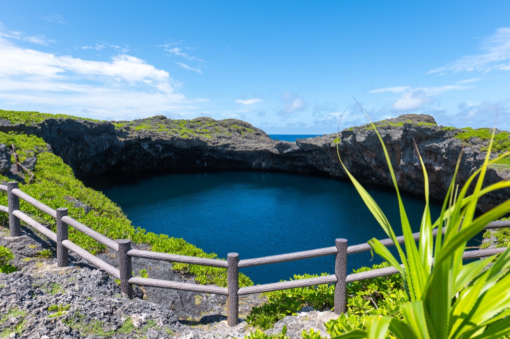 Second Toriike sinkhole on Shimoji Island with the open ocean visible just beyond the cliff edge