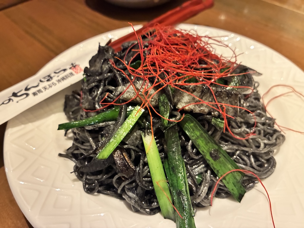 Squid-ink yakisoba — jet-black noodles with green onion and red chili thread at Umi no Chinbora