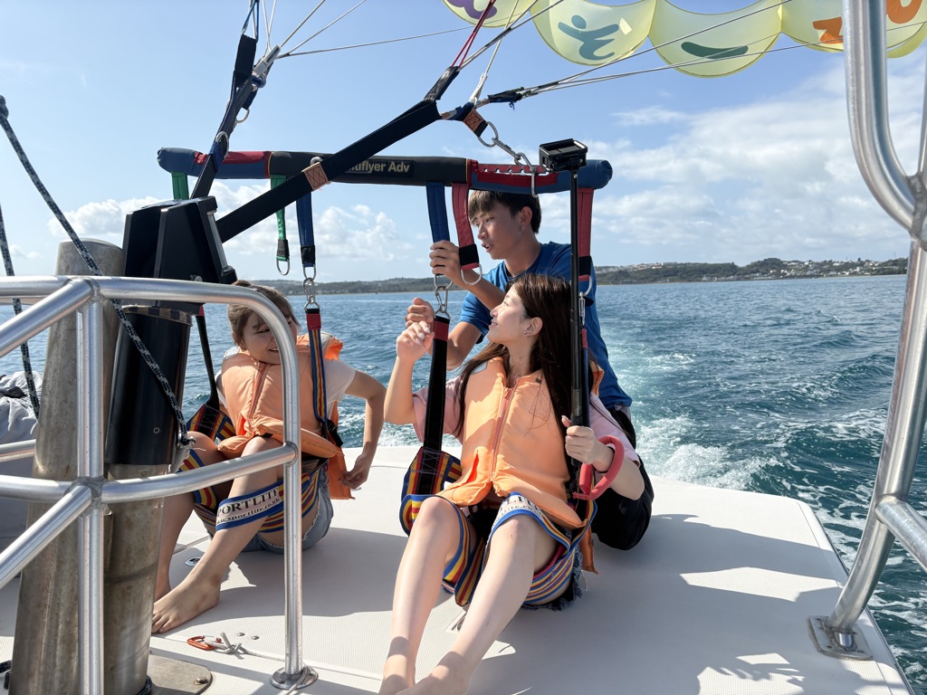 Okinawa parasailing harnesses are connected to the smiley parachute lines before liftoff