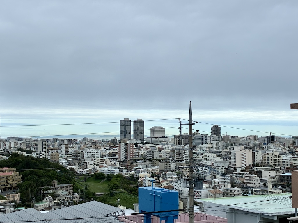 Cityscape of Naha, Okinawa under heavy gray clouds during typhoon season — a typical sight from June through October