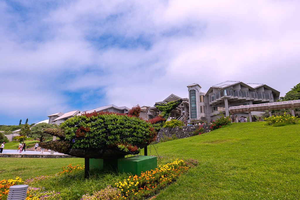 Whale-shaped topiary and greenery in Ocean Expo Park in front of the aquarium