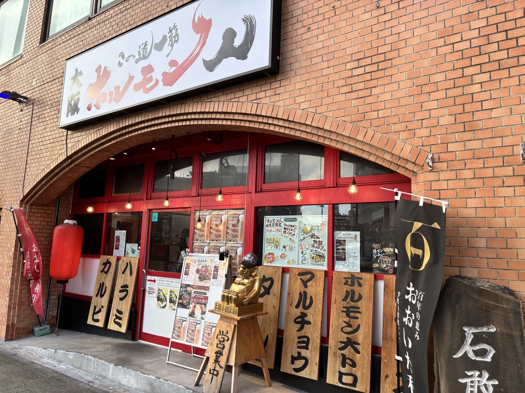 Traditional Japanese yakiniku restaurant storefront with red awnings and lanterns