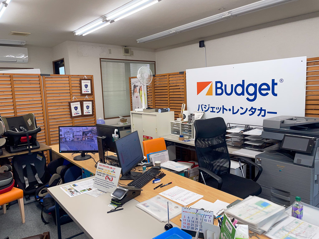 Nagano rental car pickup counter at Budget Rent-a-Car Karuizawa Ekimae with logo and child seat