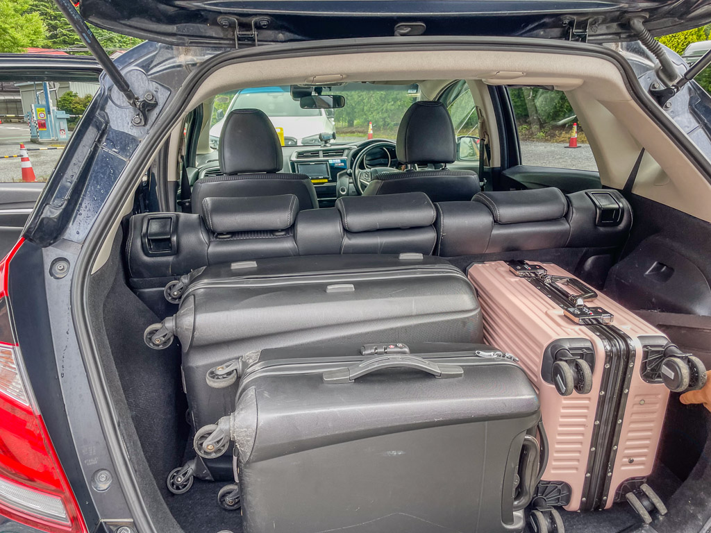 Rear seats folded down with two large and one medium suitcase in the Honda FIT boot