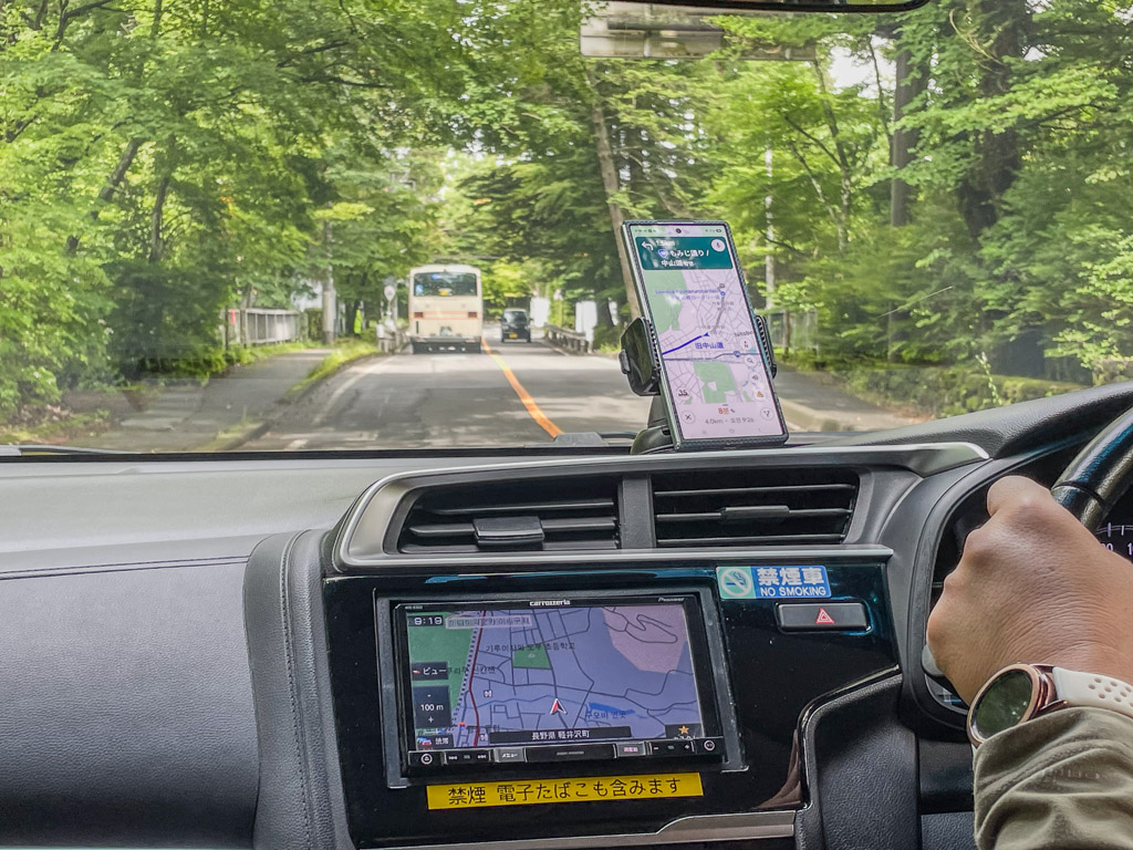 Dashboard view with smartphone Google Maps on a mount and Japanese factory navigation below