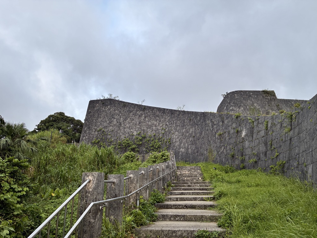 Stone stairway climbing toward the curved Ryukyu ramparts of Shuri Castle