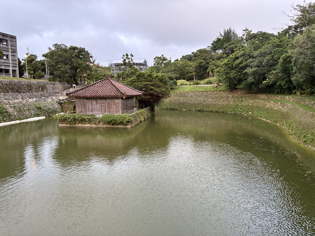 Small red-tiled hall on an islet in a Shuri Castle pond at dusk