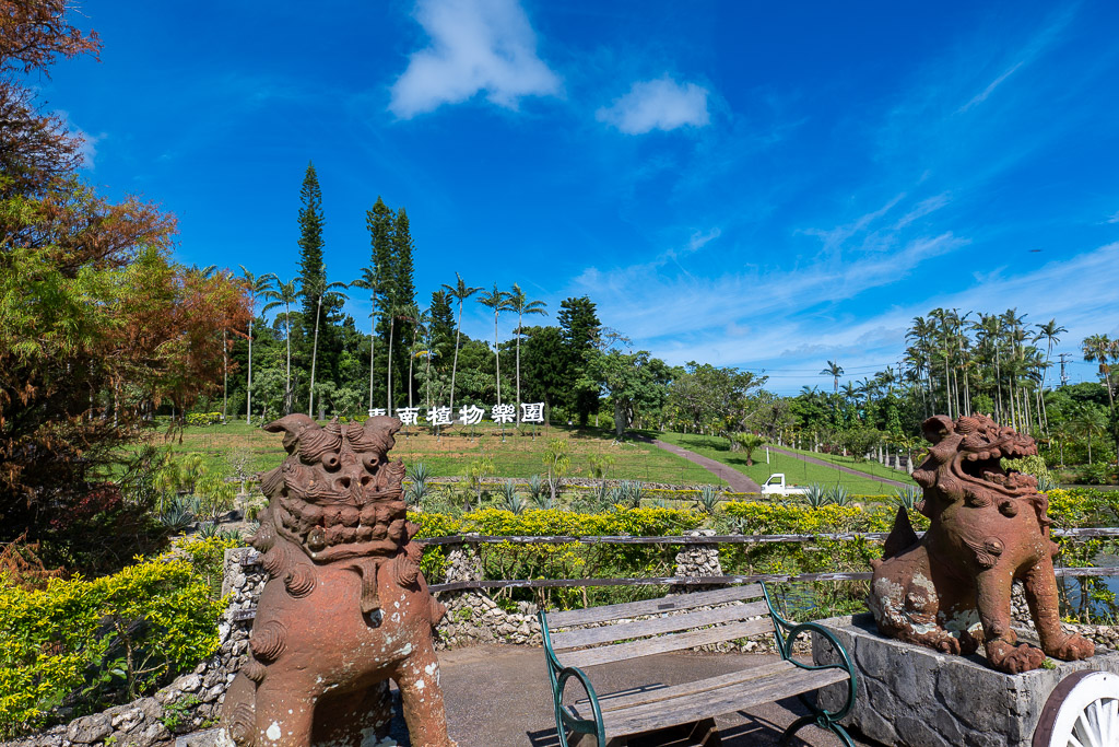 Pair of Okinawan shisa lion statues overlooking the garden and hillside sign