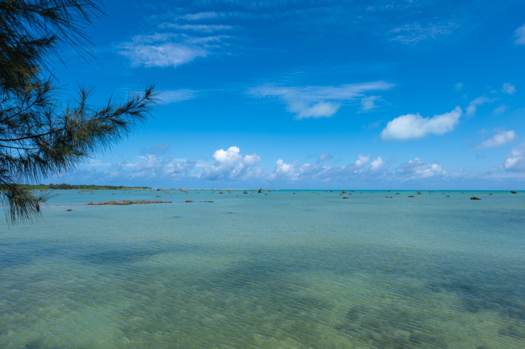 Wide shallow tidal flats at Sawada-no-hama Beach with scattered coral boulders under an open Miyako sky
