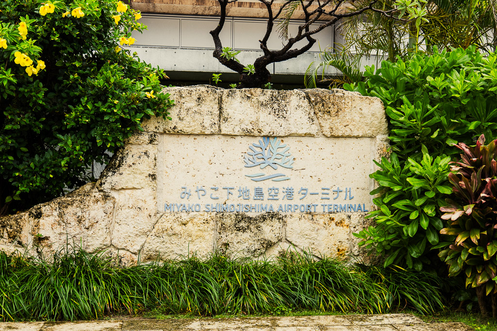 Miyako Shimojishima Airport Terminal front entrance sign surrounded by tropical greenery
