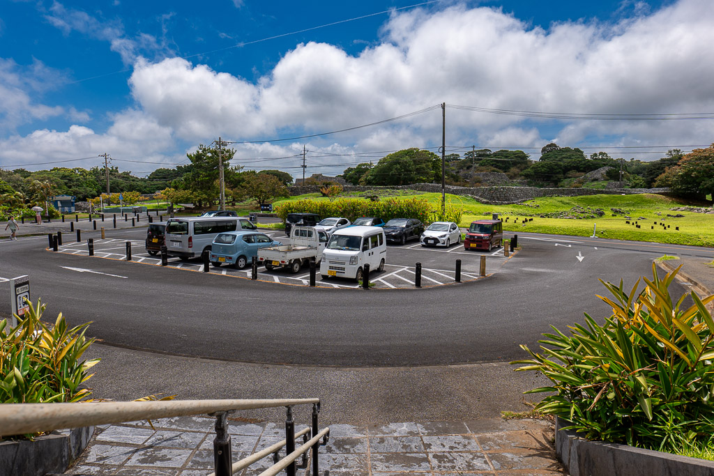 Free parking lot at Nakijin Castle Ruins with view of the castle wall in the background