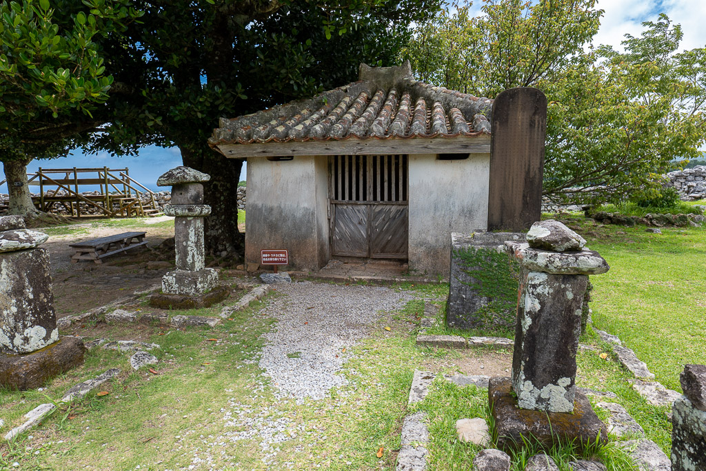 Front view of the Kouri-den small stone shrine inside Nakijin Castle with stone lanterns