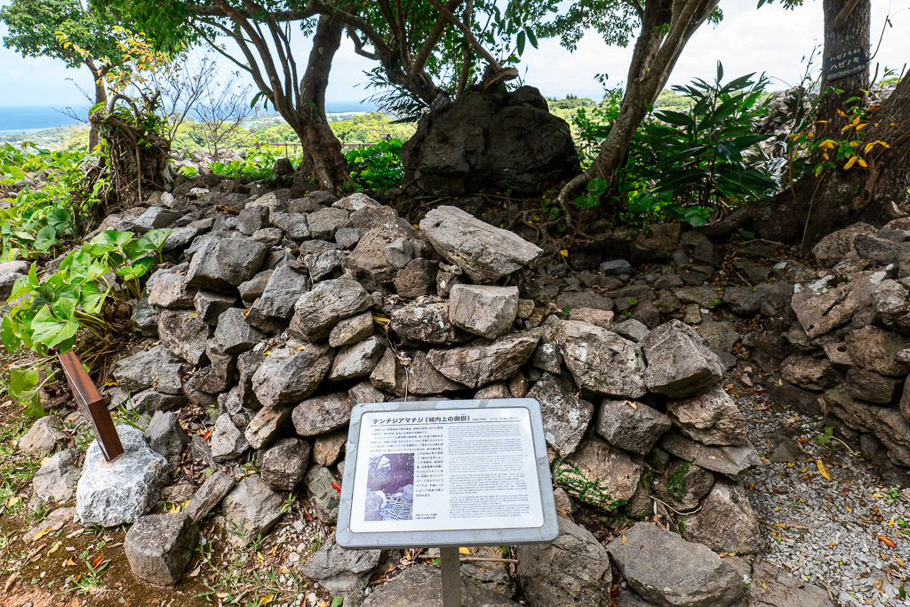 Piled stones and archaeological explanation panel at the Shigemamon site in Nakijin