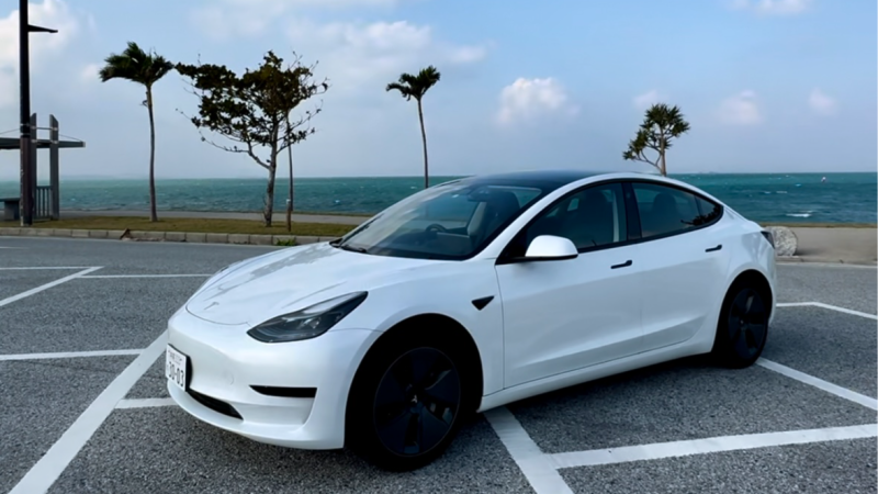 Tesla Model 3 parked at an Okinawa coastal lot before pickup with Lightmarks EV Rental