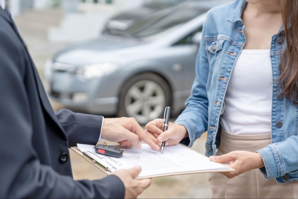 Signing a rental car agreement beside the vehicle in Hokkaido