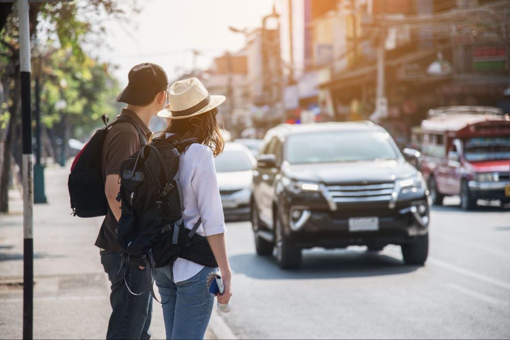 Travellers beside a rental car on a Hokkaido road trip