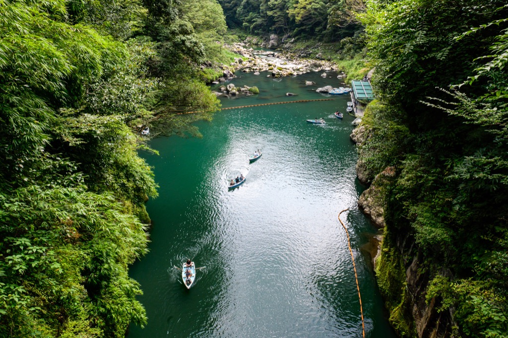Rowboats on the blue water of Takachiho Gorge, seen from above