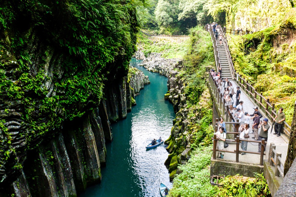 Walking path beside the rock walls and river at Takachiho Gorge