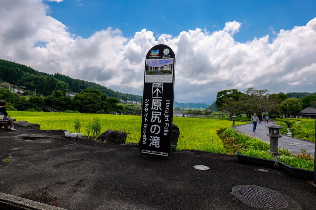 Harajiri Falls signboard against the rice-field backdrop