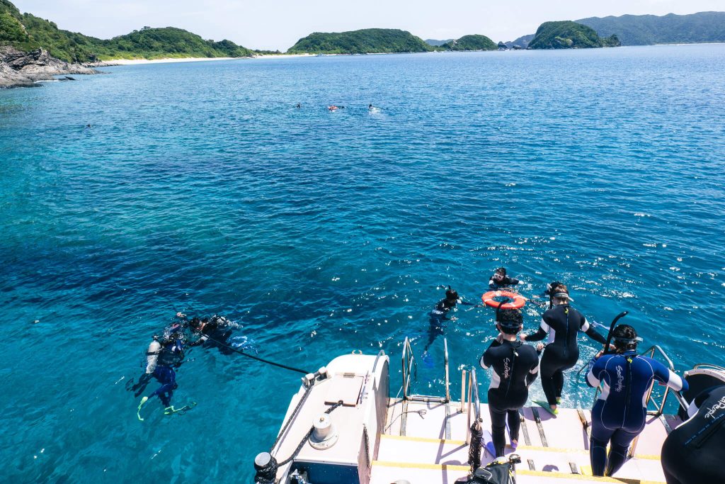 Divers entering the water from a dive boat off the Kerama Islands in Okinawa