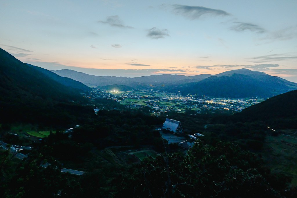 Yufu Silky Road twilight panorama with Yufuin basin lights and mountain ridgelines including Mt Yufu on the horizon
