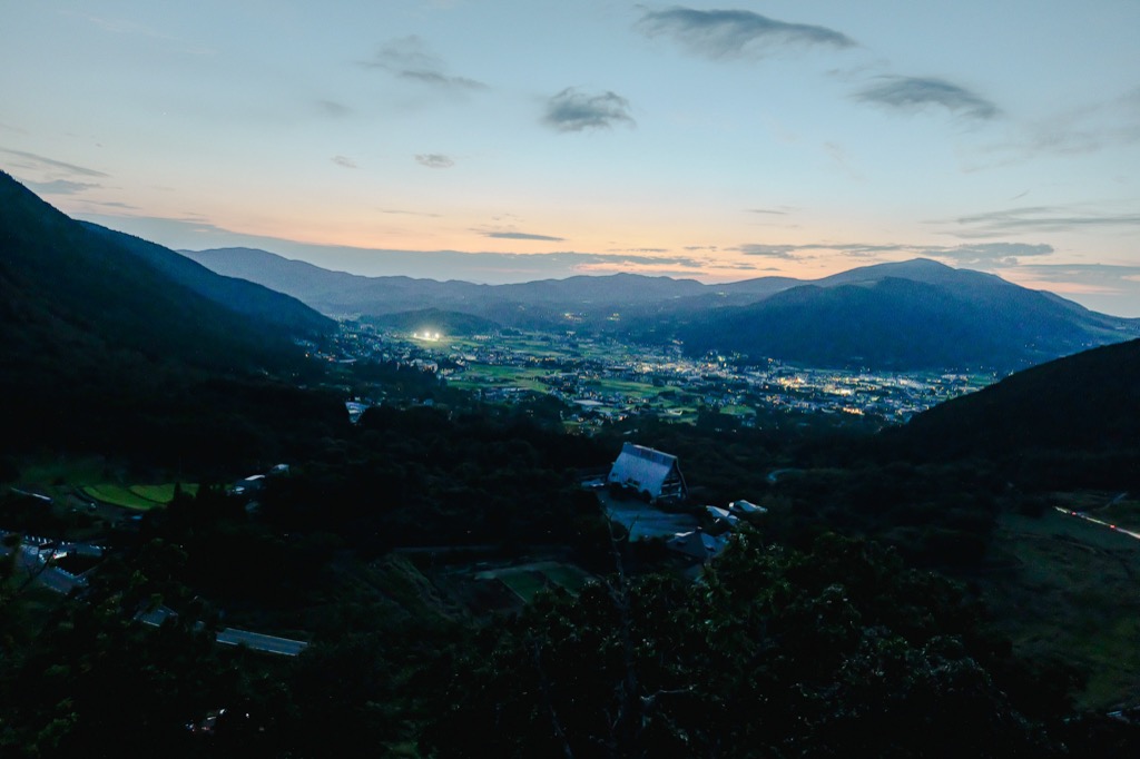 Sagiridai viewpoint at dusk with the Yufuin basin lights beginning to glow